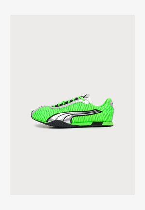 Basket de sport vert vif avec texture en mesh, détails argentés et noirs, semelle noire et fermeture à lacets, vue de côté sur fond blanc.