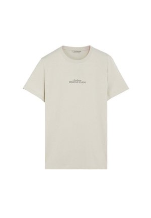 Beige T-shirt med korte ærmer, rund halsudskæring og lille tekst "Scalpers CREATIVE STUDIO" trykt i midten foran.