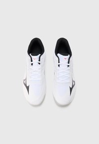 Chaussures de sport blanches avec une tige en mesh texturé, des accents noirs et une semelle extérieure translucide. Comprend des lacets plats et un logo sur la languette.