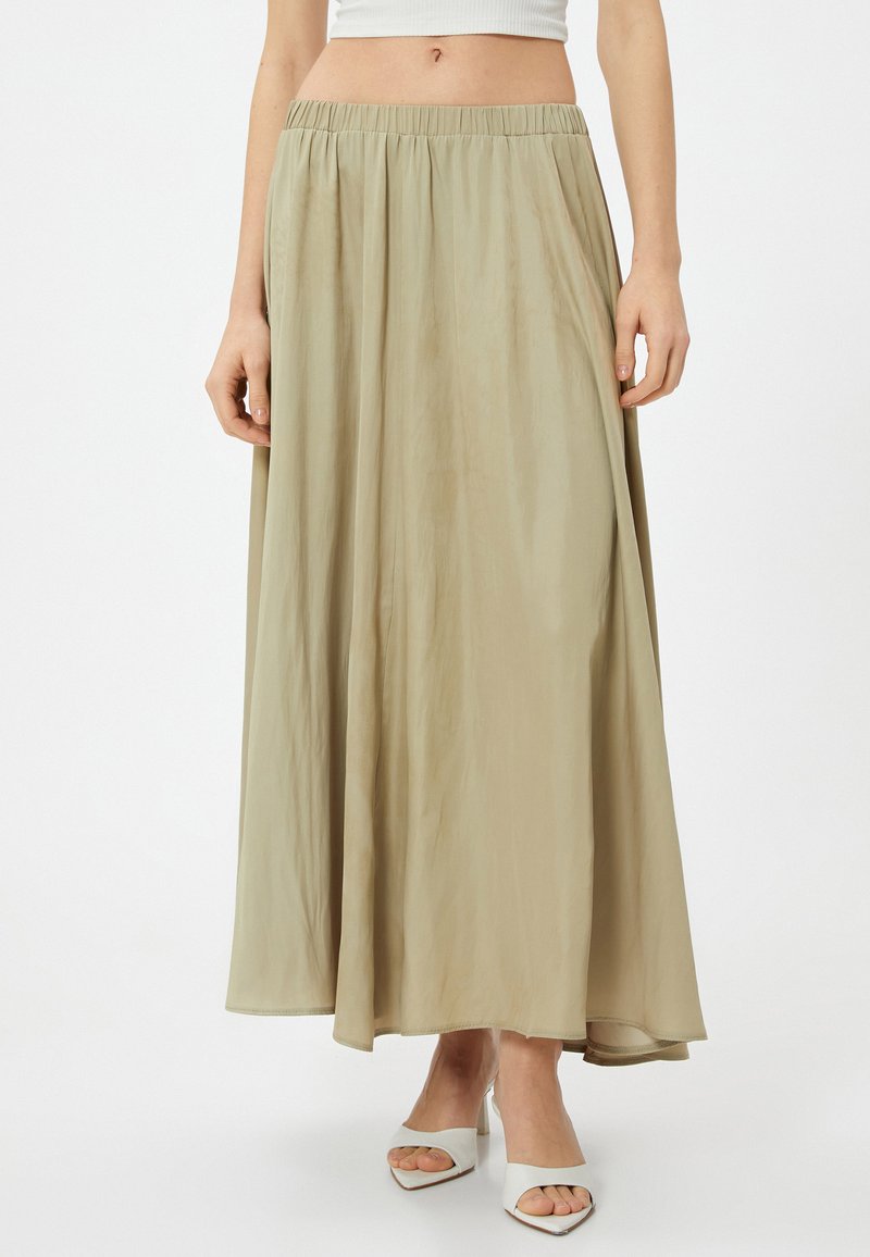 Falda maxi beige, fluida, con una cinturilla elástica; hecha de un tejido ligero y suave. Presenta una silueta relajada en A.