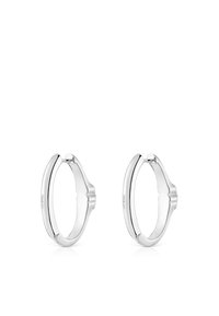 Pendientes de aro de plata con un acabado liso y pulido. Presentan una curvatura distintiva y un sutil detalle geométrico cerca del cierre.