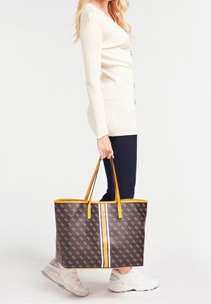 Grand sac fourre-tout en marron foncé avec un motif logo, des accents jaunes et un centre rayé blanc. Poignées jaunes solides.