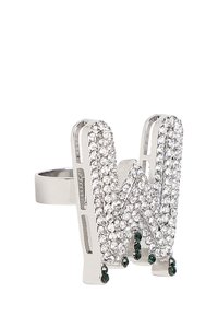 Anillo de plata con una "W" estilizada adornada con strass claros y piedras de acento verdes, que presenta un diseño geométrico y un acabado pulido.