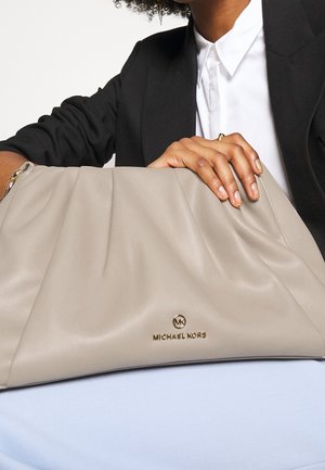 Beige Michael Kors handbag made of soft leather, featuring pleats and a gold logo accent. Smooth texture with a slouchy shape.