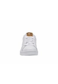 Valkoiset sneakerit, joissa on sileä nahkapinta, pyöreä kärki, perinteinen nauhakahdatus ja vaaleanruskea K-Swiss-logopatchi kielellä.