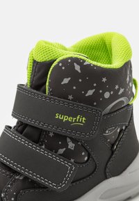 Scarpe alte da bambino nere con motivi a tema spaziale grigi, accenti verdi e cinturini regolabili in Velcro. Rivestimento in rete morbida.