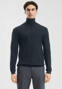 Granatowy sweter w golfie z miękkiej dzianiny, z długimi rękawami i dopasowanym krojem. Gładka struktura bez widocznych wzorów.