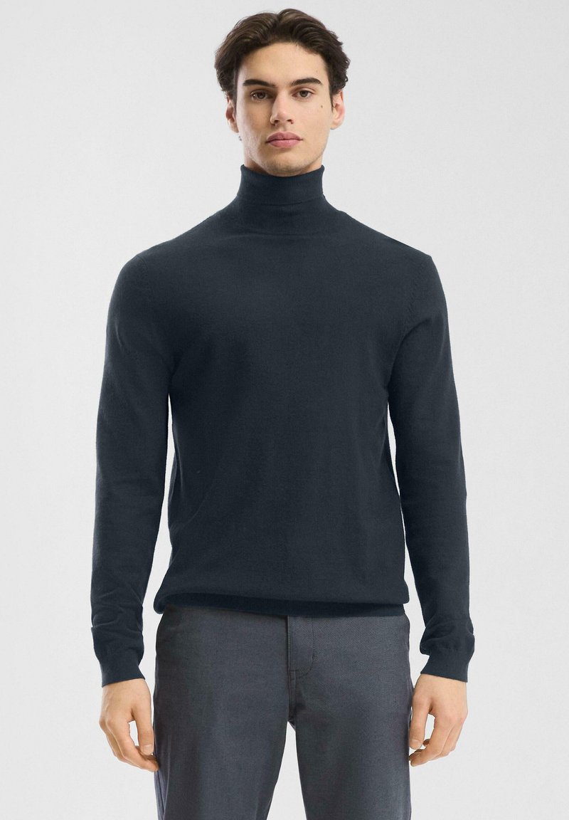 Granatowy sweter w golfie z miękkiej dzianiny, z długimi rękawami i dopasowanym krojem. Gładka struktura bez widocznych wzorów.