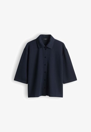 Donker marineblauw overhemd met korte mouwen, wijde kraag en losse pasvorm, afgebeeld tegen een effen witte achtergrond.