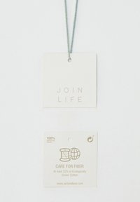 Bílá látková visačka se zeleným provázkem, s embosovaným textem "JOIN LIFE" a druhou visačkou uvádějící "100% recyklovaný papír" s pokyny pro péči.