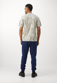 adidas Sportswear FEELCOZY PANT - Παντελόνι φόρμας - dark blue/white