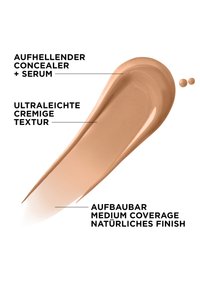 Correcteur et sérum à la texture ultra-légère et crémeuse, couvrance moyenne modulable et fini naturel, présentés en trace beige et gouttelettes.
