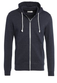 Sudadera con cremallera en color marino, hecha de tela suave, con una cremallera frontal, dos bolsillos laterales y cordones blancos en la capucha.