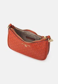 Pomarańczowa torebka crossbody z fakturowanej skóry Michael Kors z złotymi akcentami, zamknięciem na zamek błyskawiczny i kieszeniami wewnętrznymi. Posiada charakterystyczny detal z logo.