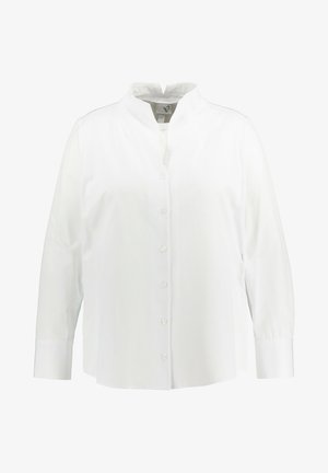 Camicia bianca con colletto alto, maniche lunghe e vestibilità comoda. Realizzata in tessuto morbido con chiusure a bottone equidistanti.