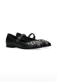 Scarpe basse in pelle nera con un design a punta, caratterizzate da numerosi rivetti metallici in oro e argento, e una cinturino alla caviglia regolabile.
