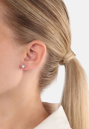 Silberne Ohrstecker mit floralem Design, verziert mit klaren Edelsteinen. Glänzende Oberfläche mit polierter Verarbeitung.