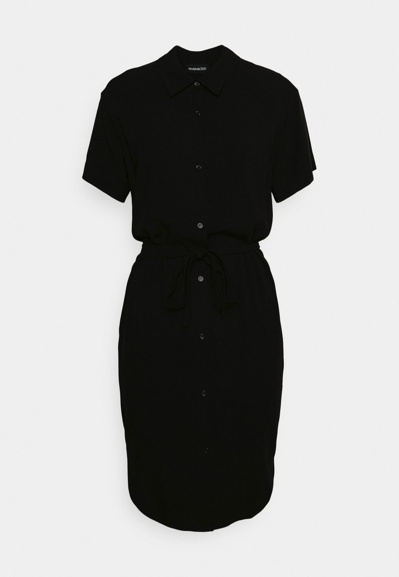 Robe chemise noire à manches courtes avec col, boutonnée sur le devant et ceinture à nouer à la taille, présentée sur un fond clair uni.