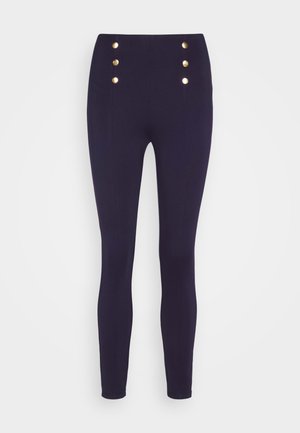 Navy high-waisted pants made of stretchy fabric, featuring gold button accents on the front, tapering down to the ankle.