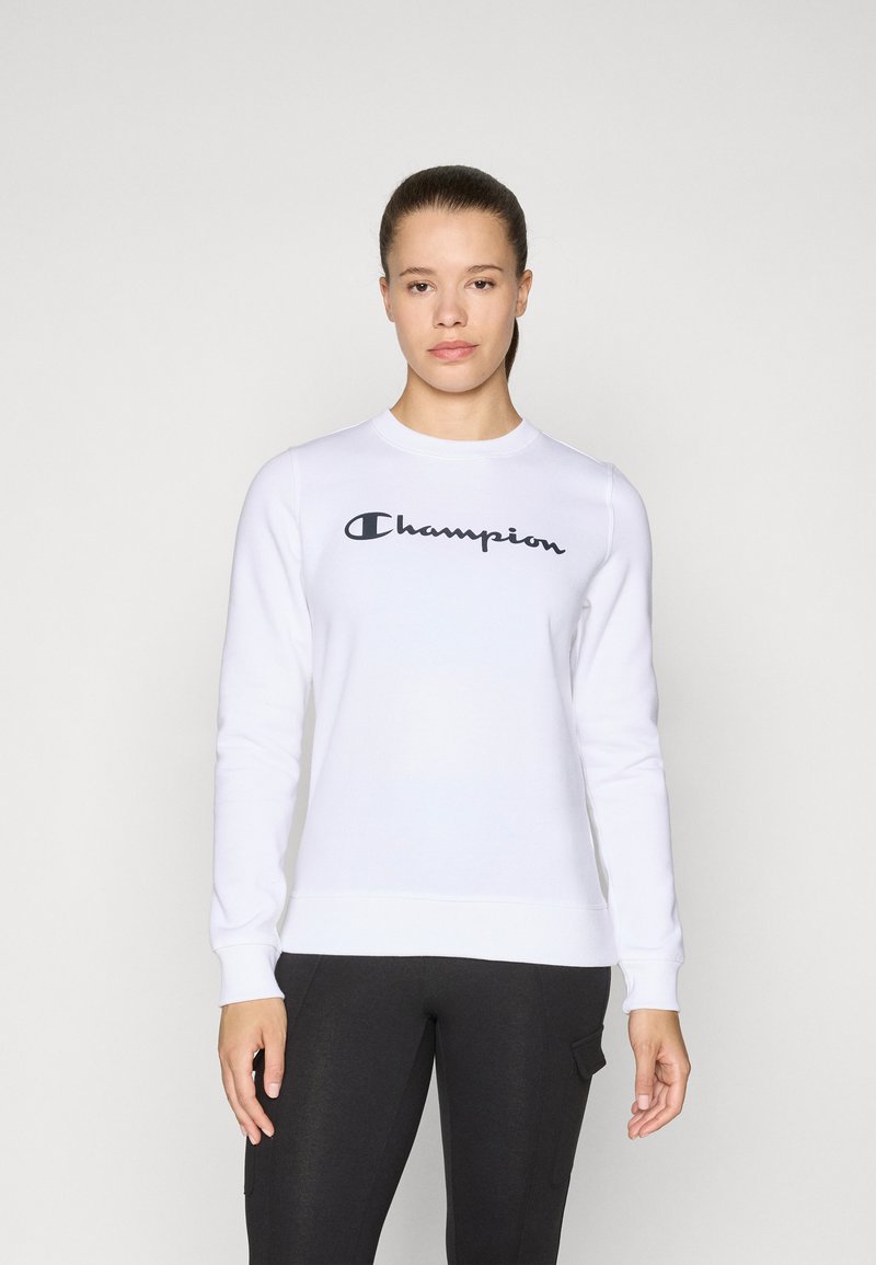 Sweatshirt blanc en mélange de coton avec des manches longues, des poignets côtelés et un col rond. Présente un logo noir "Champion" sur la poitrine.
