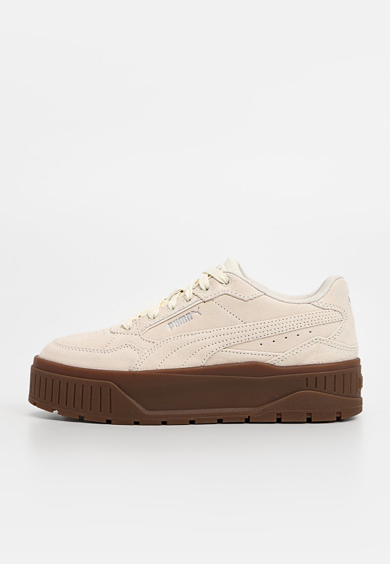 Sneakers beige in suede con suola piatta in gomma marrone, dotati di fori di ventilazione, design con lacci e un logo sottile sul lato.