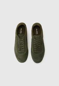 Sneakers verzi din suede cu vârf rotund, design cu șireturi și accente tonale. Interiorul are o branț negru cu logo-ul mărcii.