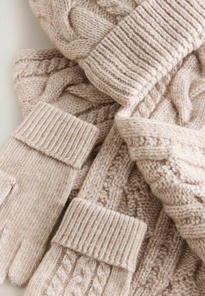 Beige stickad scarf och handskar med ett kabelstickat mönster och ribbade manschetter. Mjuk textur med ett mysigt utseende och varmt material.