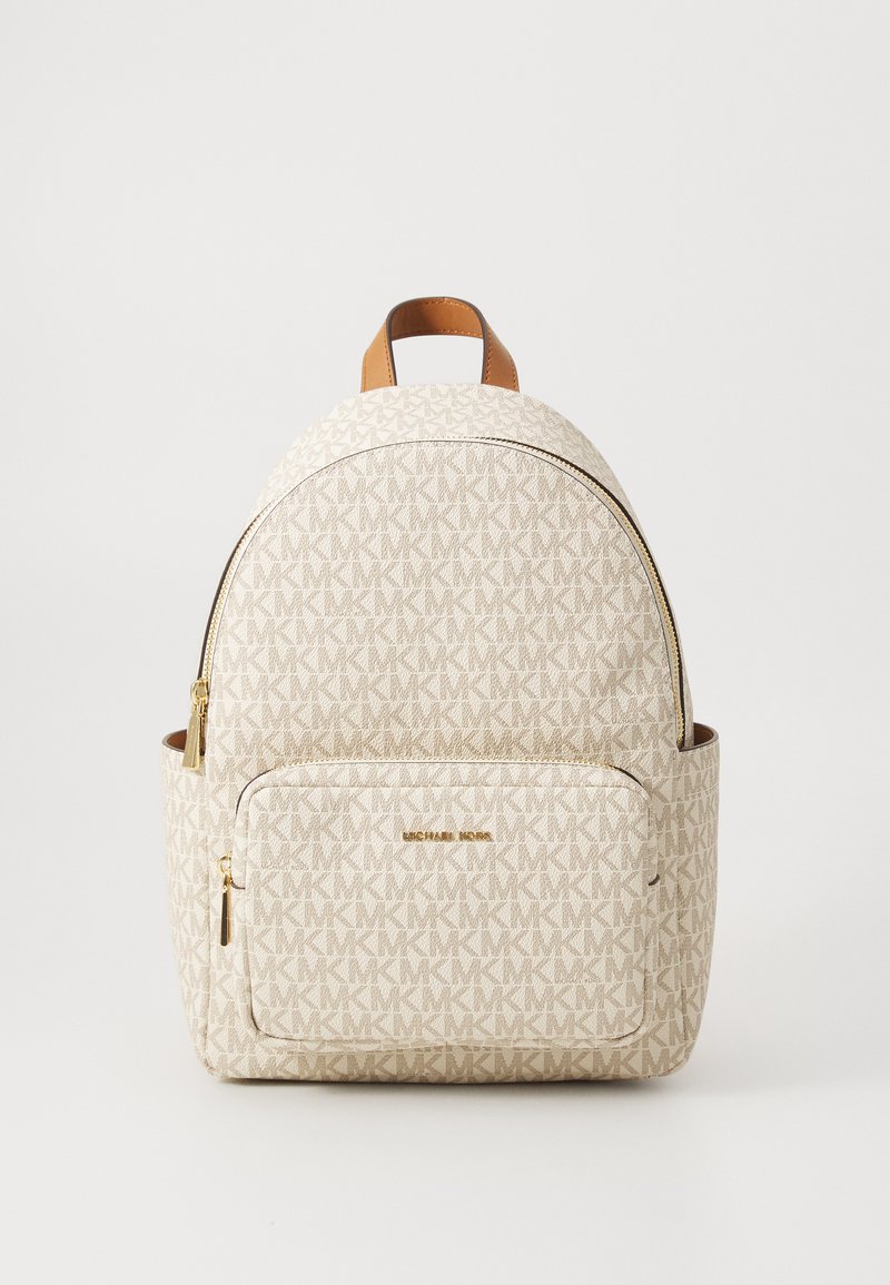 Mochila de tecido com padrão bege, apresentando um bolso frontal com fecho e detalhes em pele castanha. A ferragem em tom dourado destaca o design.