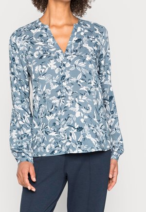 Chemisier à manches longues bleu clair avec imprimé floral blanc. Doté d'un décolleté en V et de poignets ajustés. Tissu doux et texturé avec une coupe décontractée.