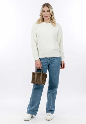 Un pull blanc fluffy, un jeans taille haute bleu clair, et un petit sac à main en fausse fourrure marron avec des anses courtes, sur un fond blanc.