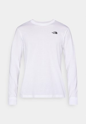 Balta krekla ar garām piedurknēm, izgatavota no mīkstas auduma; kreisajā krūtīs un manžetēs ir neliels melns logotips. Parasts piegriezums ar apaļu kakla izgriezumu.