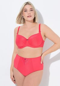Un set di lingerie fucsia composto da un reggiseno con punti in rilievo e dettagli in pizzo, abbinato a mutandine a vita alta, entrambi realizzati in materiale liscio.