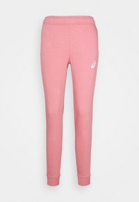 Rosa Jogginghosen mit einem elastischen Bund und schmalen Bündchen. Hergestellt aus weichem Material, mit einem kleinen weißen Logo auf dem linken Oberschenkel.