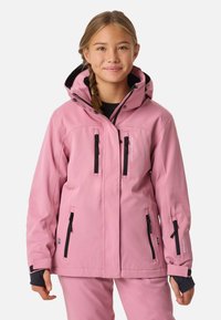 Veste imperméable rose avec une capuche bordée de noir, plusieurs poches zippées et des poignets élastiques. Présente un logo sur le côté gauche.