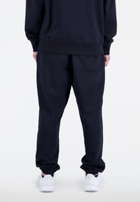 New Balance ESSENTIALS STACKED LOGO FRENCH TER - Pantalones deportivos - black