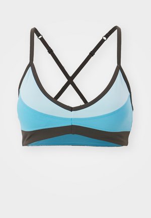Reggiseno sportivo azzurro chiaro con accenti marroni scuri, caratterizzato da una forma triangolare allungata, spalline incrociate e una texture liscia.