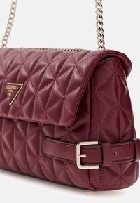 Borsa a tracolla in pelle trapuntata color bordeaux con chiusura a patta, ferramenta argentata e tracolla a catena. Presenta cuciture a forma di diamante e dettaglio con fibbia.