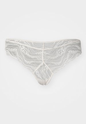 Lace thong in light gray with wavy pattern, scalloped edges, and a minimal rise, featuring a contrasting waistband and gusset.