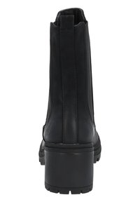 Botines negros hasta el tobillo con un tacón grueso, material de cuero suave, paneles elásticos laterales y una suela de goma texturizada. Detalles de costura simples y planos.