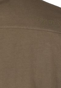 Olijfgroene shirt met korte mouwen van zachte stof, met een gestikte schouderpas en een geprint "TOP GUN"-tekst over de bovenrug.