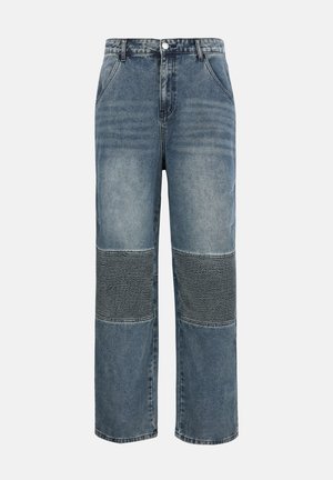 Jean en denim bleu moyen avec panneaux nervurés aux genoux, poches avant, passants pour ceinture, bouton et fermeture éclair, coupe droite et large.