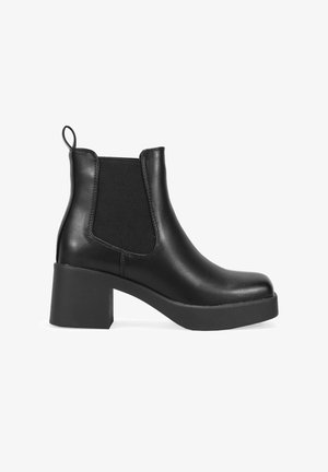 Bottines noires avec une finition en cuir lisse, des panneaux élastiques sur les côtés et un talon épais. Le design comprend une boucle à l'arrière pour un enfilage facile.