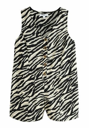 Junge Frau mit langen braunen Haaren, die ein ärmelloses, zebragestreiftes, geknöpftes Oberteil trägt und nach rechts blickt, vor einem unscharfen Außenhintergrund.