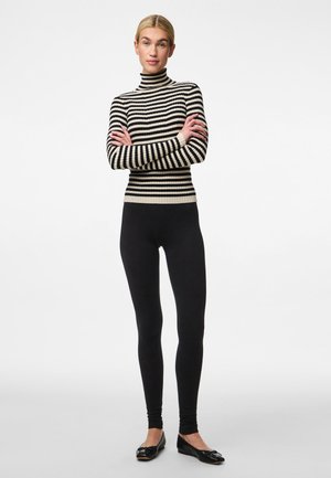 Black and white striped ribbed turtleneck sweater paired with black leggings and flat shoes. The outfit features a fitted silhouette and smooth texture.