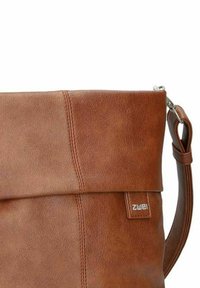 Braune Kunstleder-Schultertasche mit einem gefalteten Deckel, vertikalen Nahtdetails, verstellbarem Tragegurt und einem kleinen Logoanhänger auf der Vorderseite.