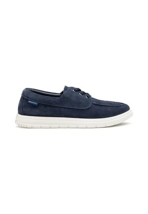 Scarpa casual stringata in camoscio blu navy con suola in gomma bianca, tallone basso ed etichetta del marchio Docksteps sul lato.