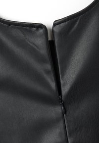 Nahaufnahme eines schwarzen Lederbekleidungsstücks mit Reißverschluss, das eine strukturierte Oberfläche und einen runden Ausschnitt aufweist und glatte Nahtdetails zeigt.