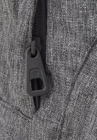 Gray fabric with a textured weave, featuring a black zipper pull and a sturdy zipper track along the edge, ensuring durability and functionality.