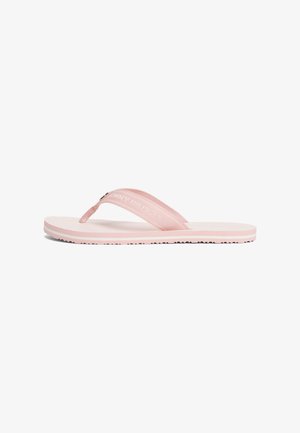 Pink flip-flop med en struktureret sål, bløde stofstropper og en gummisål med små skridsikre punkter. Logo trykt på stroppen.