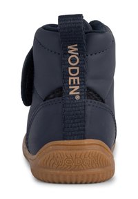 Zapato infantil azul marino con un diseño resistente, que presenta una correa de tejido, suela de goma y el logo "WODEN" en relieve en la parte posterior.